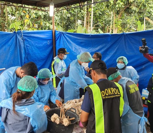 GALI: Petugas Polda Sumut melakukan penggalian makam warga yang diduga jadi korban saat tinggal di kerangkeng mirip sel tahanan milik Mantan Bupati Langkat Non Aktif Terbit Rencana Perangin Angin.(Foto: Humas Polda Sumut)